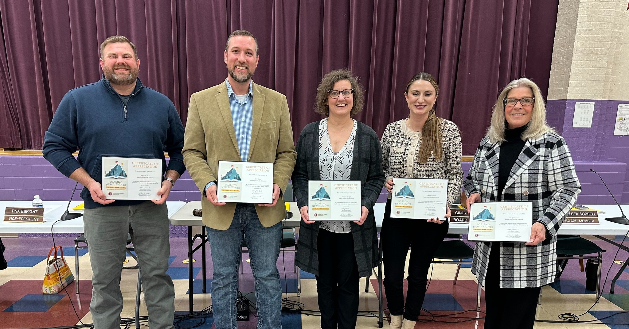 Members of the school board holding certifications of appreciation 